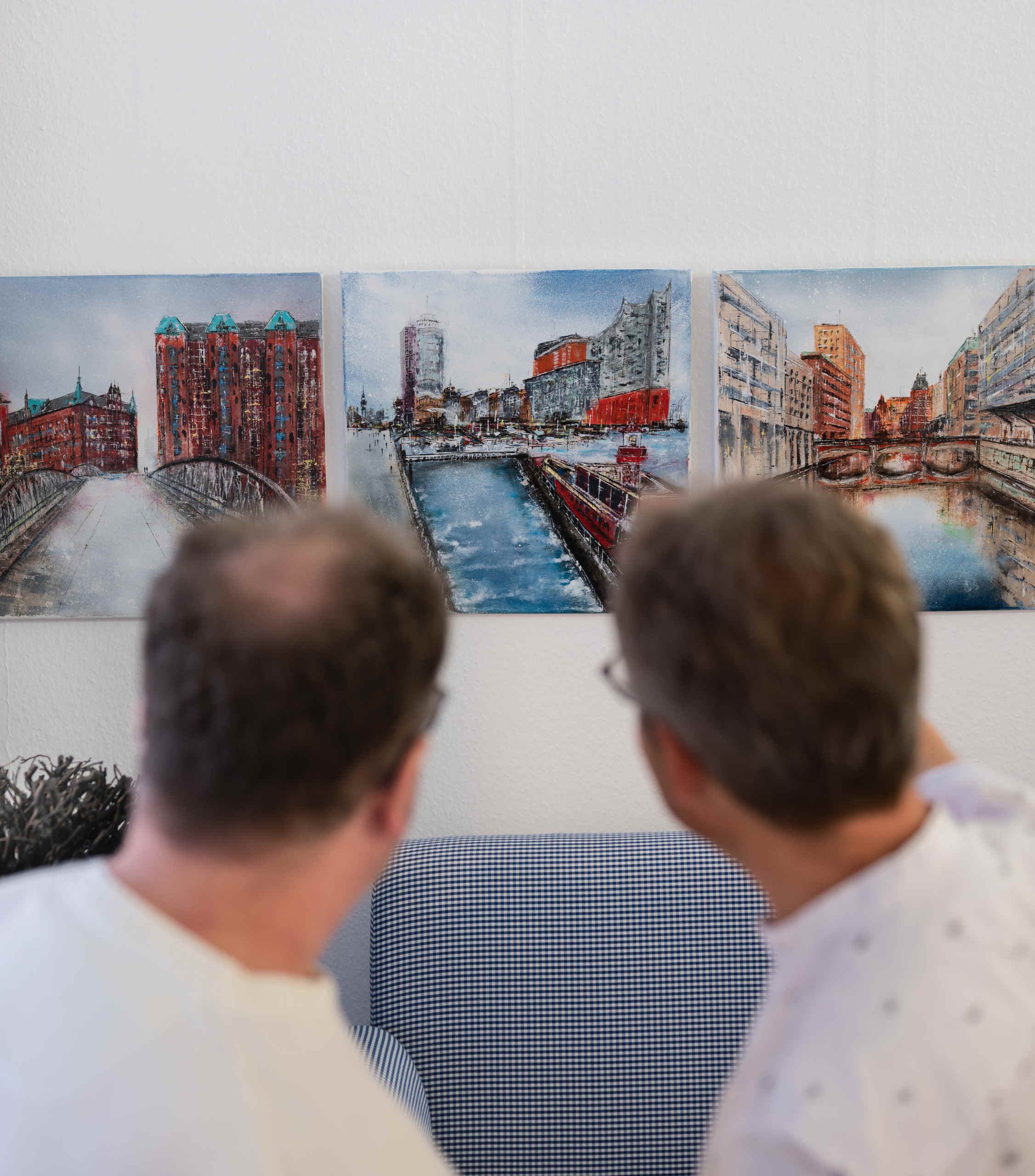 Gäste betrachten Bild bei Vernissage der Ausstellung „Stadt & Wasser – Lebendige Harmonie“ bei KOCH - DIE RAUMHANDWERKEREI