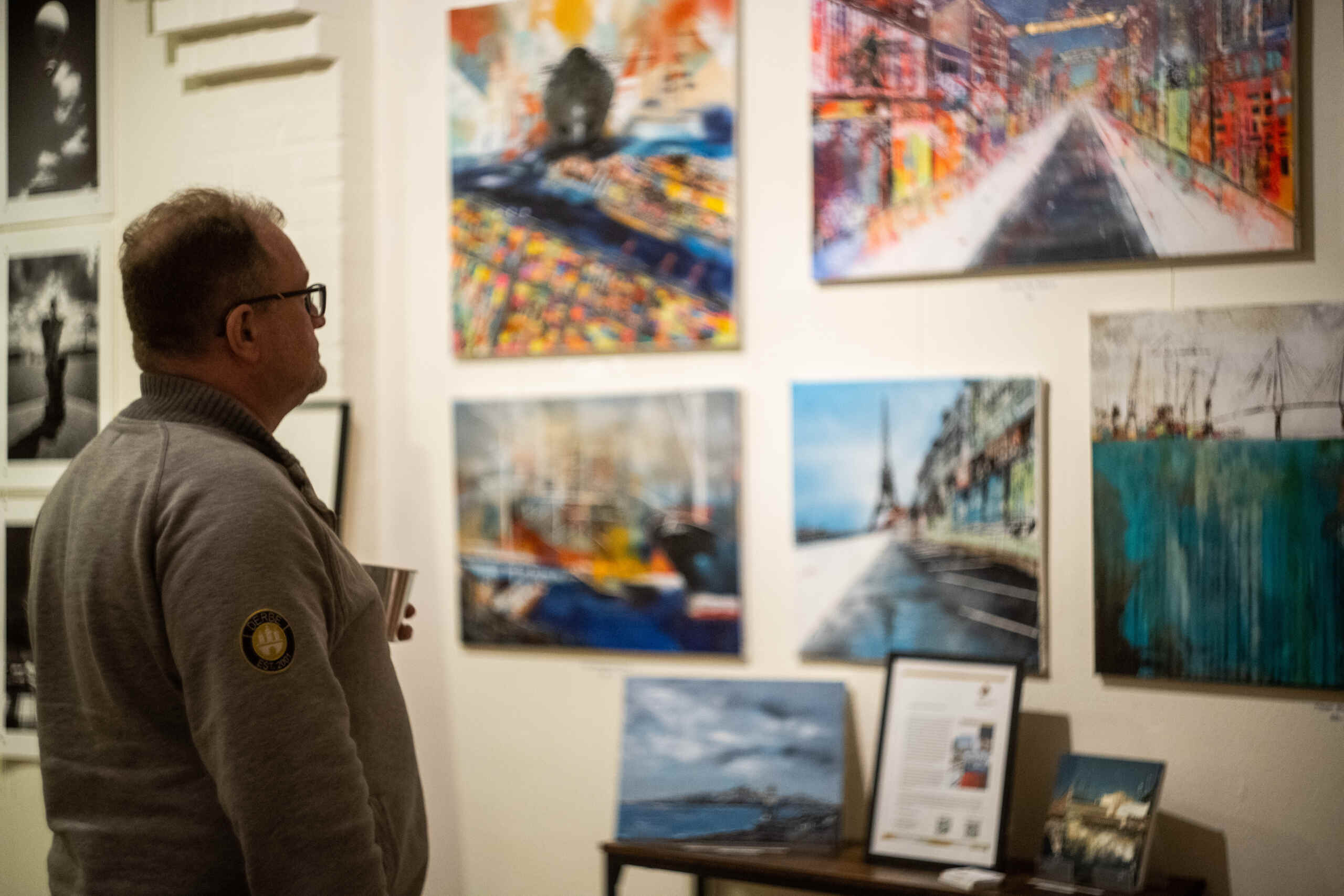 Kunstinteressent betrachtet Nina Groths Werke auf der Vernissage der Ausstellung „Stadtspaziergänge“ in der kleinen Galerie in Flottbek