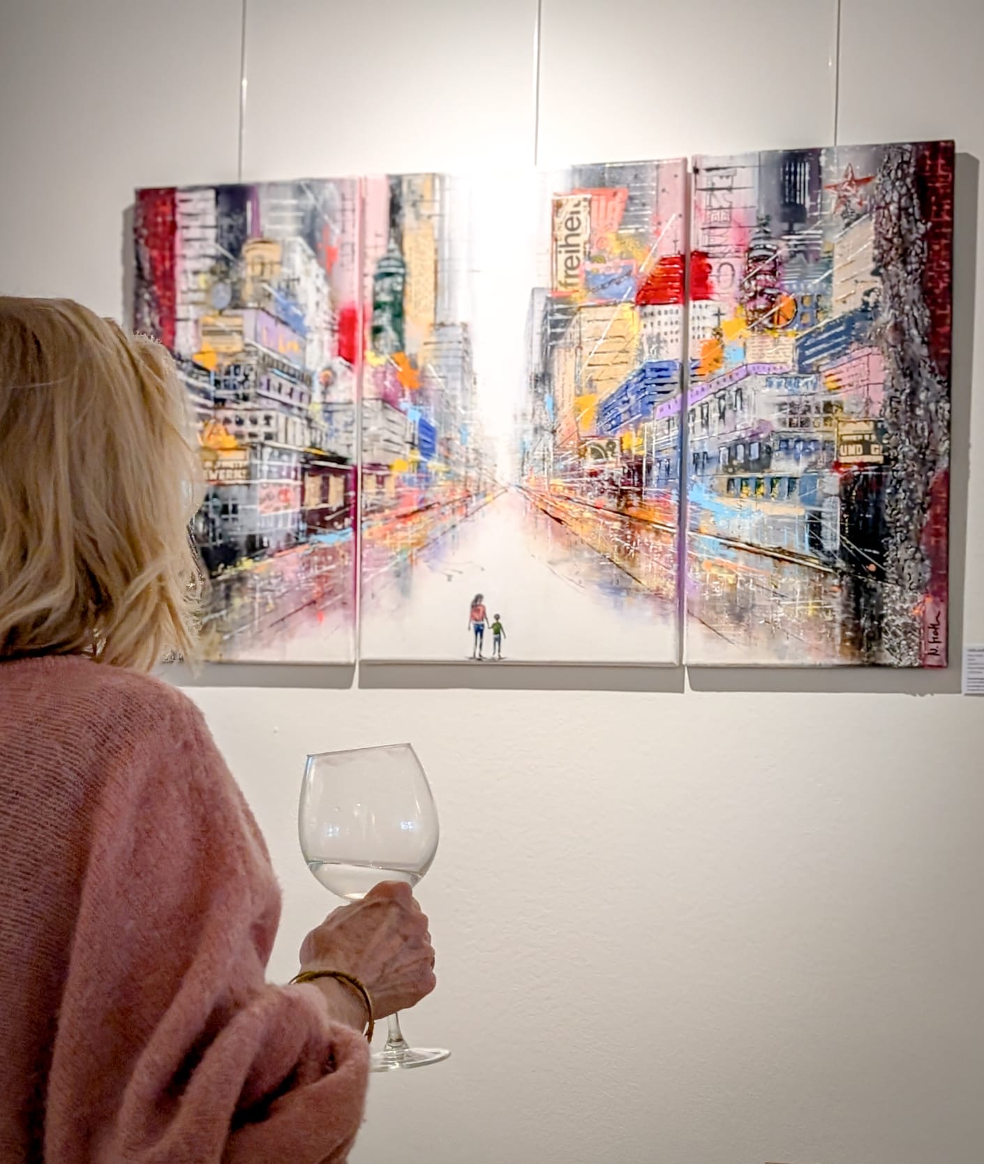 Ausstellung in einem Immobilienbüro Betrachterin sieht sich Kunst von Nina Groth bei einer Ausstellung in einer Immobilienfirma an