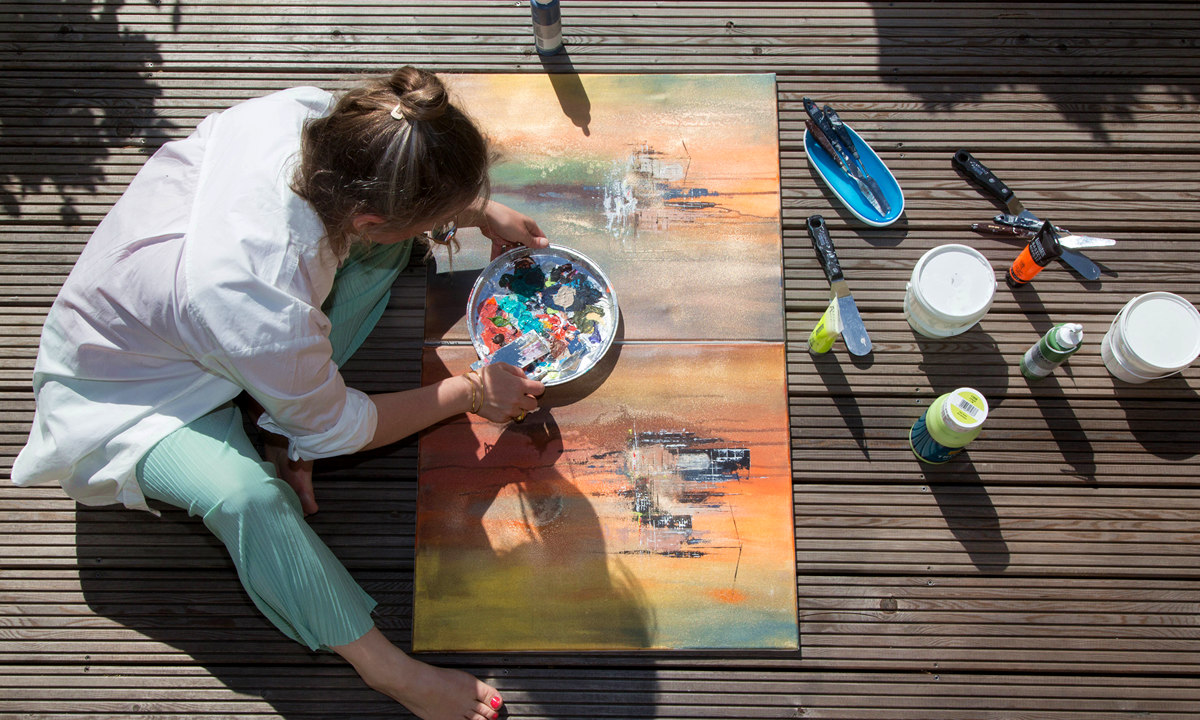 Künstlerin Nina Groth arbeitet an zwei Gemälden auf einer Dachterrasse Nina Groth arbeitet an neuen Gemälden