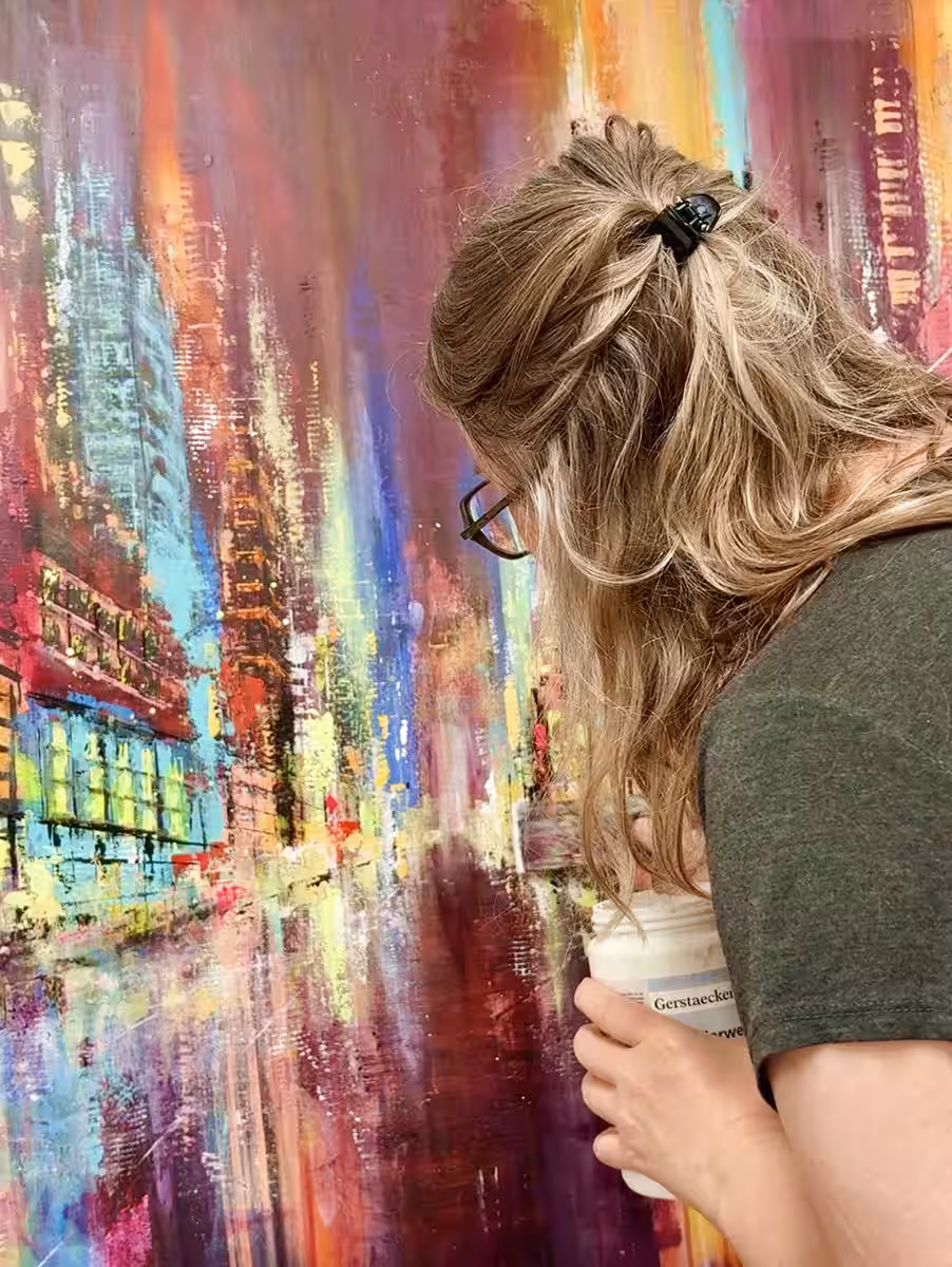 Nina Groth bei der Arbeit an einem Stadtgemälde Künstlerin Nina Groth arbeitet im Atelier an einem farbenreichen, zentralperspektivischen Stadtgemälde
