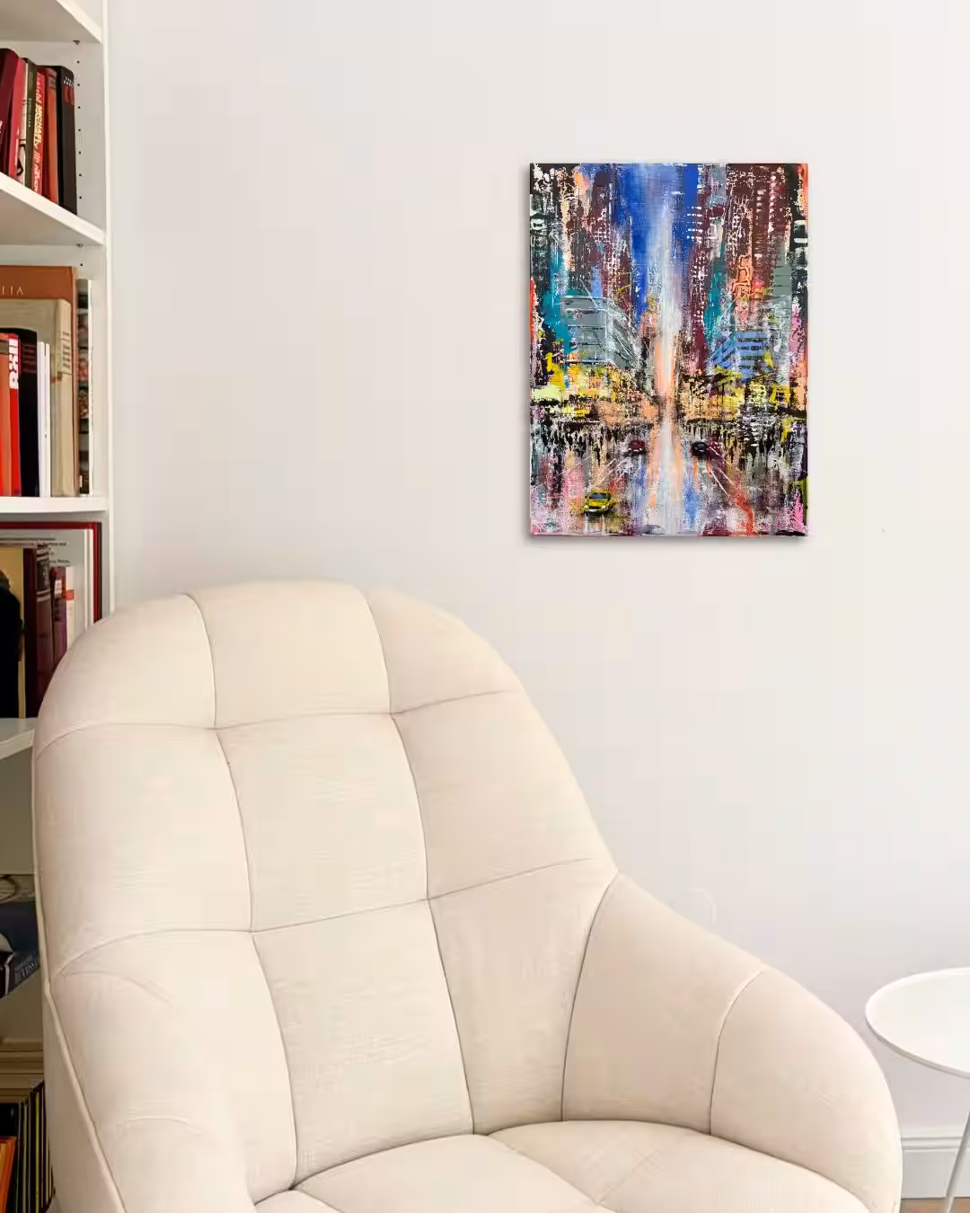 Urban Axis – Fragments of Order I | Moderne Stadtmalerei im Wohnraum Farbenfrohe Mixed-Media-Stadtlandschaft von Nina Groth an einer hellen Wand über einem cremefarbenen Sessel in einem modernen Wohnraum.